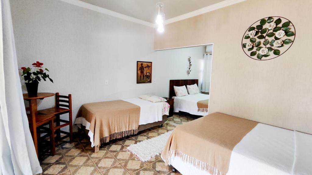 a hotel room with two beds and a mirror at Pousada Nascente do São Francisco in Vargem Bonita
