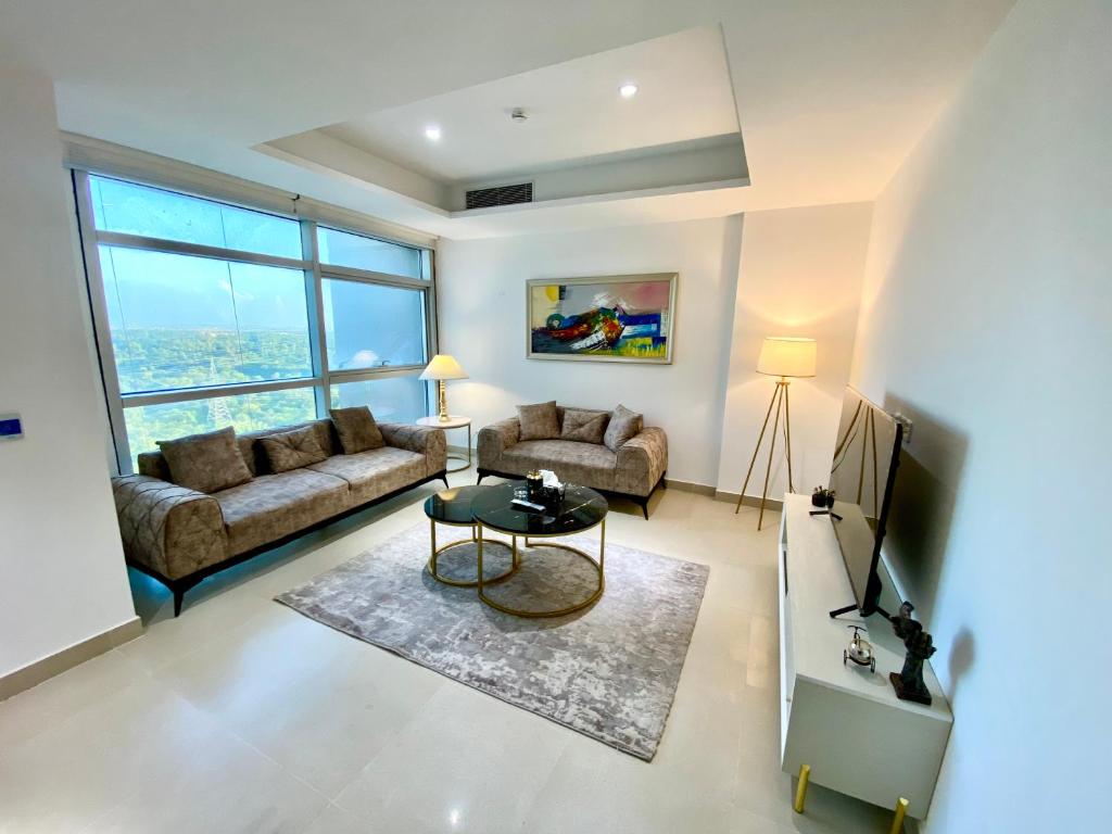 a living room with a couch and a table at One Constitution Avenue - Apartments by Superhost in Islamabad