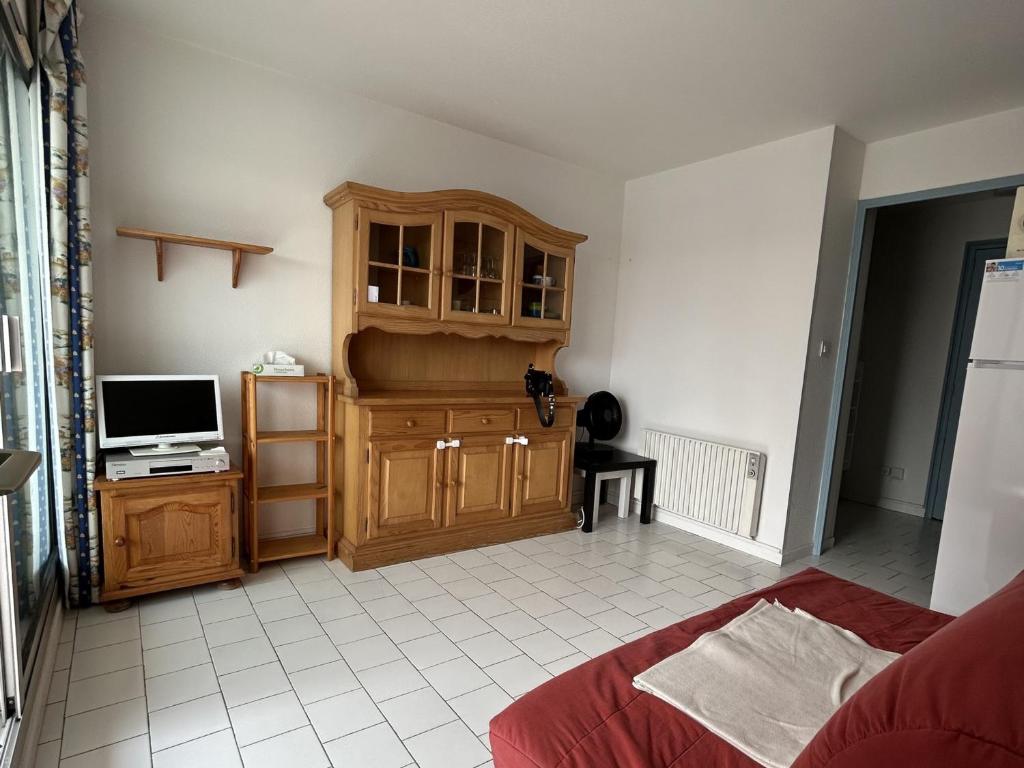 Cette chambre comprend un lit, une télévision et une armoire. dans l'établissement Confortable 2 pièces cabine à Sète, proche plage et commerces - FR-1-338-516, à Sète