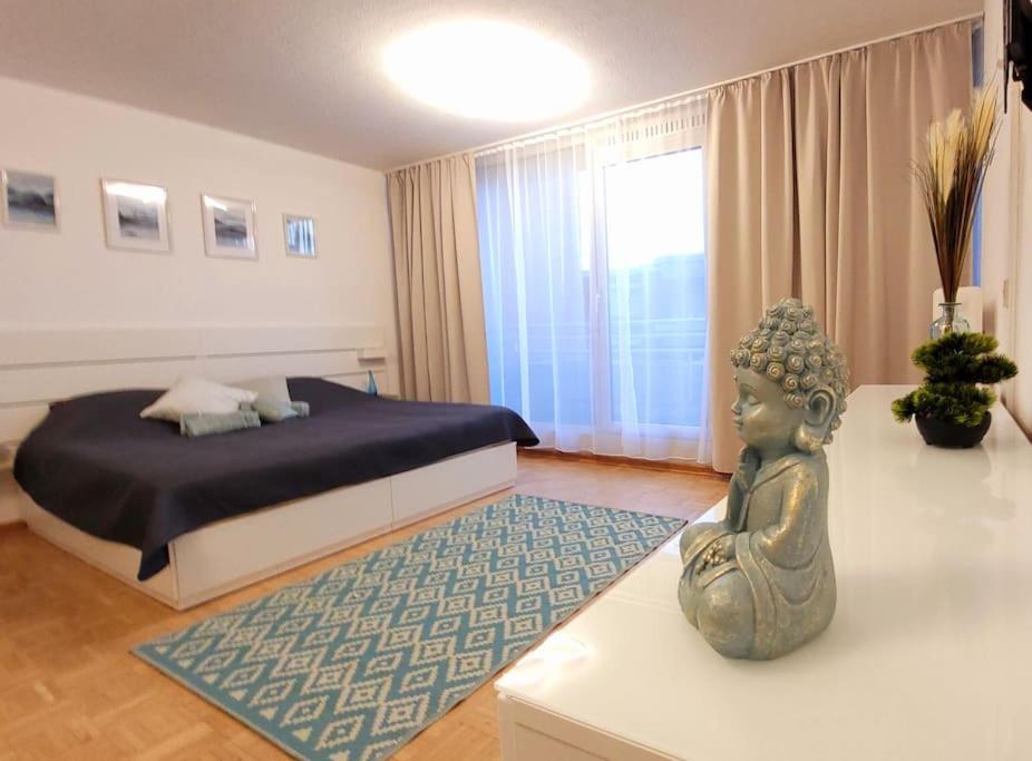 - une chambre avec un lit et une statue sur une table dans l'établissement Essen-Steele, 2-Zimmer, 4 Person, à Essen