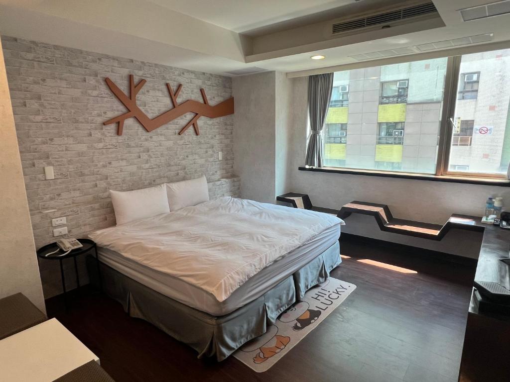 1 dormitorio con cama y pared de ladrillo en Kaili Hot Spring Hotel, en Jiaoxi