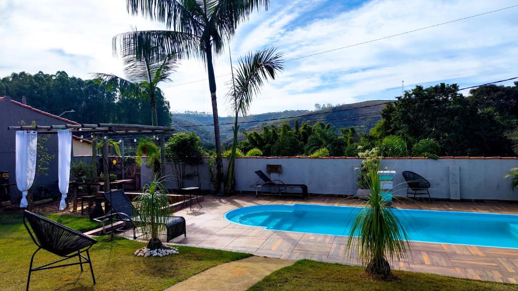 a backyard with a swimming pool and a palm tree at Pousada Nascente do São Francisco in Vargem Bonita