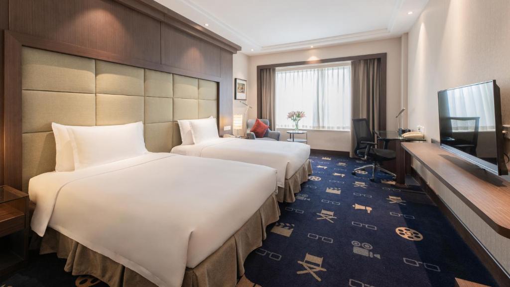 a hotel room with two beds and a television at Crowne Plaza Shanghai by IHG in Shanghai