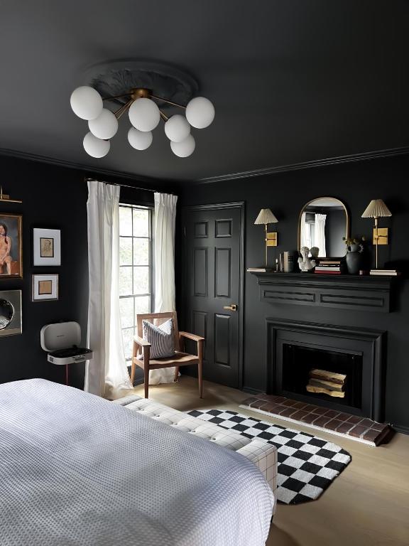 a black bedroom with a bed and a fireplace at MrNomad Boutique Hotel Parisian Townhouse in Dallas