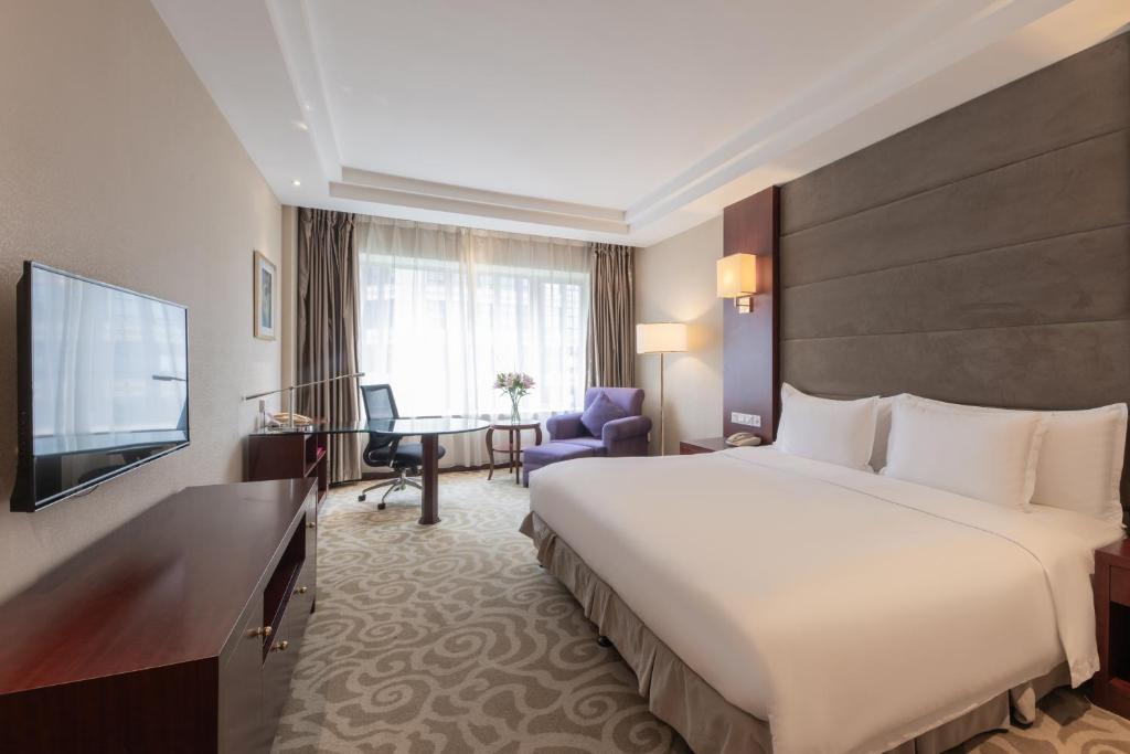 a hotel room with a large bed and a desk at Crowne Plaza Shanghai by IHG in Shanghai