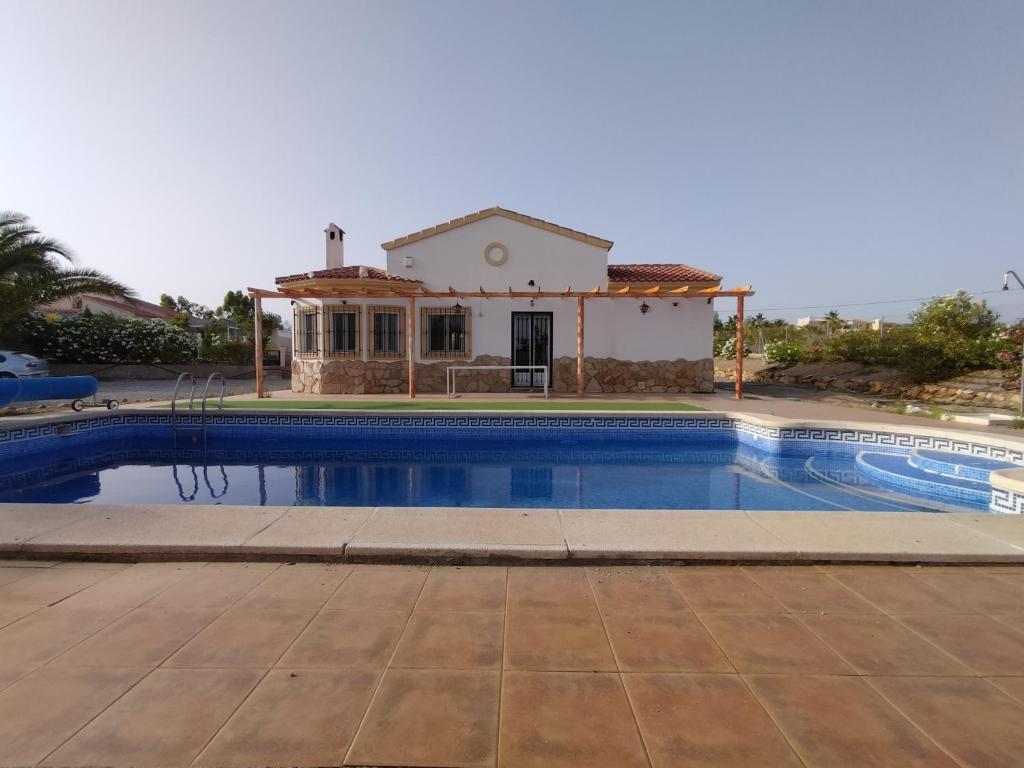 a villa with a swimming pool in front of a house at CASA ÁNGEL LAS LABORES ALBOX in Albox
