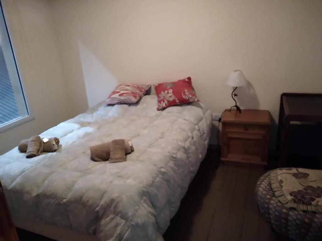 a bedroom with a bed with two stuffed animals on it at Los alamos in Río Gallegos
