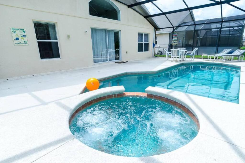 a swimming pool with an orange in the middle at 201 Hideaway beach 4 beds - pool&spa in Kissimmee