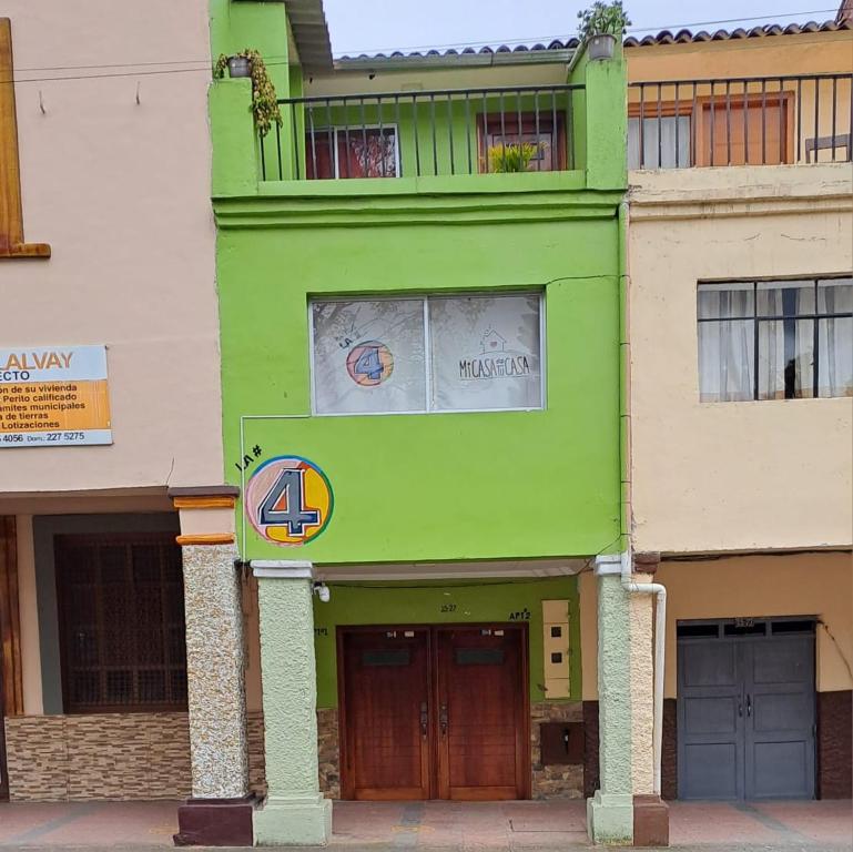 um edifício verde com uma varanda em cima em "La #4 Mi Casa es tu Casa"Apt #1 Giron, Azuay,Ecuador 