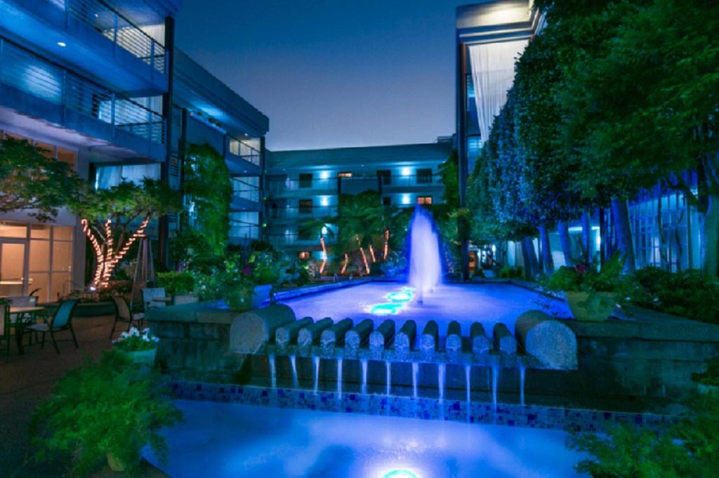 a fountain in front of a building at night at Cupertino Hotel in Cupertino