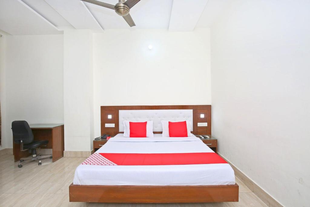 um quarto com uma cama grande e almofadas vermelhas em OYO Nimantran Resort em Baddi