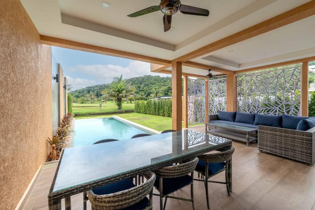 uma sala de estar com mesa e cadeiras e uma piscina em Ocean Grove Pool Villa - Koh Chang em Ko Chang