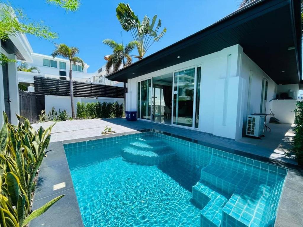 a swimming pool in front of a house at Palm Oasis Pool Villa by Pattaya Holiday in Jomtien Beach