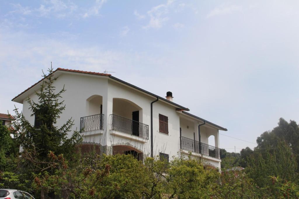 a white house with a balcony on a hill at House in Caramagna in Imperia