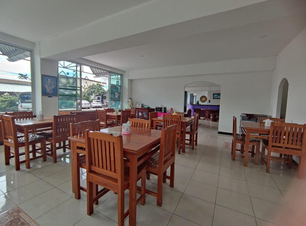 comedor con mesas y sillas de madera en ERAWAN PLACE, en Mae Sot