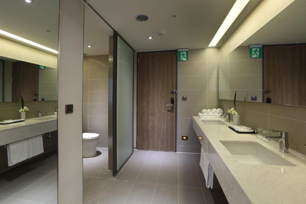 a bathroom with two sinks and a toilet at Just Sleep Kaohsiung Zhongzheng in Kaohsiung