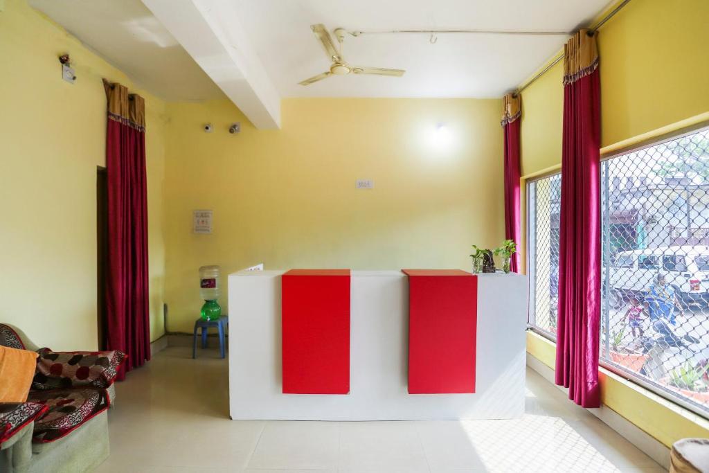 a living room with red and white furniture and a window at OYO Hotel Shree Balajee 1 in Puri