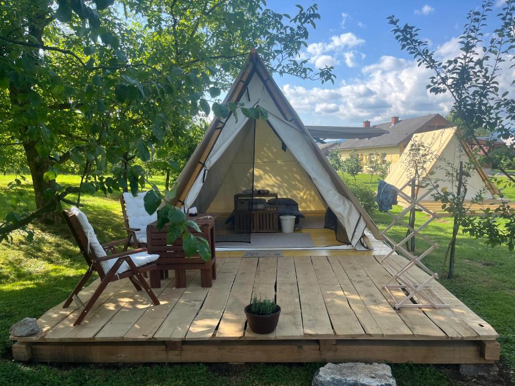 a tent with a wooden deck in a yard at Na vrtu K25 in Gradac