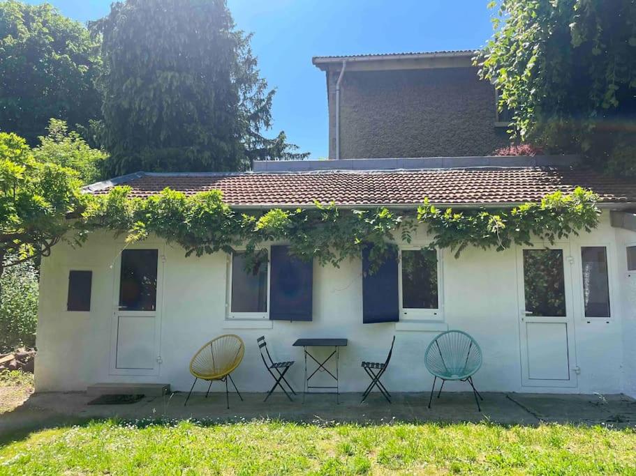 une maison blanche avec des chaises devant elle dans l'établissement Brand new Tiny House w garden, à Saint-Cloud