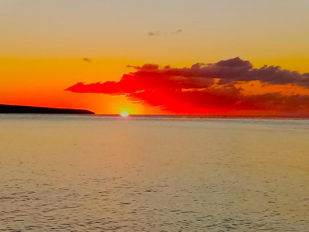 a sunset over the ocean with the sun setting at Vatupau Beachfront Bungalows in Port Vila