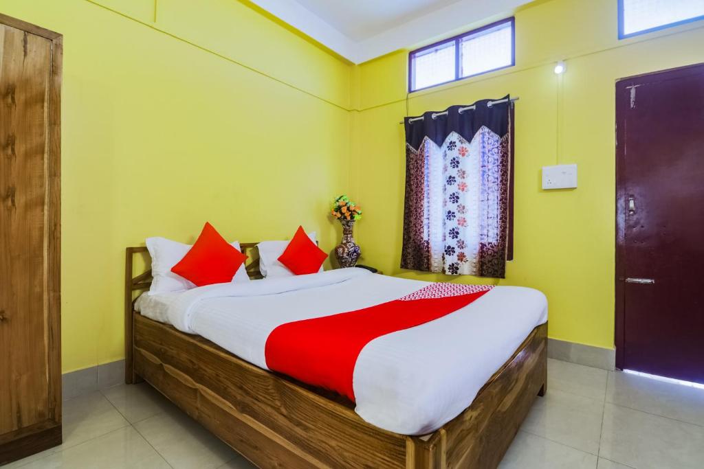 1 dormitorio con 1 cama grande con almohadas rojas en OYO Alohi Ghar, en Bhutiāgāon