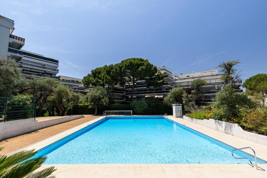een zwembad voor een gebouw bij Appartement 6 couchages dans résidence avec piscine in Juan-les-Pins