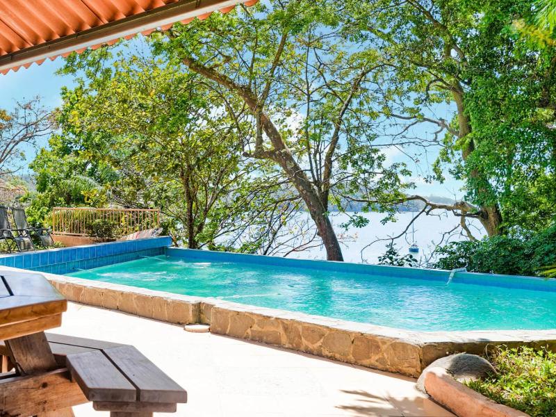 una gran piscina en un patio con árboles en Boca Chica BnB at Gone Fishing Panama Resort, en Boca Chica