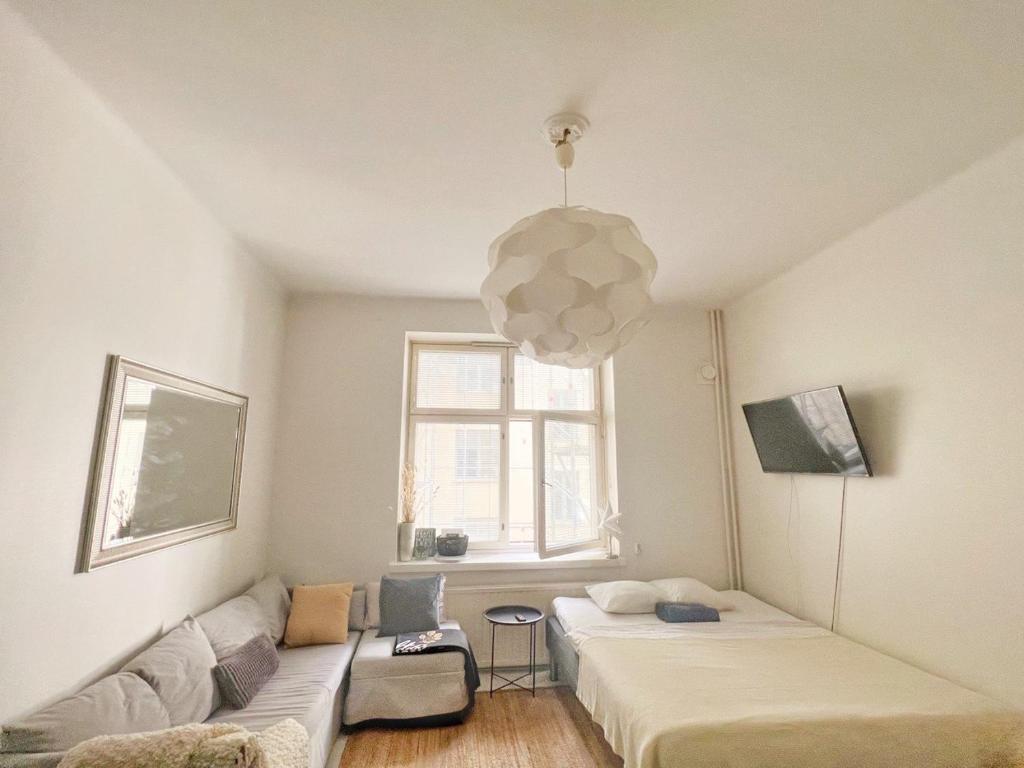 uma sala de estar com duas camas e um sofá em Sweethome Studio 49 in City Center Punavuori district em Helsinque
