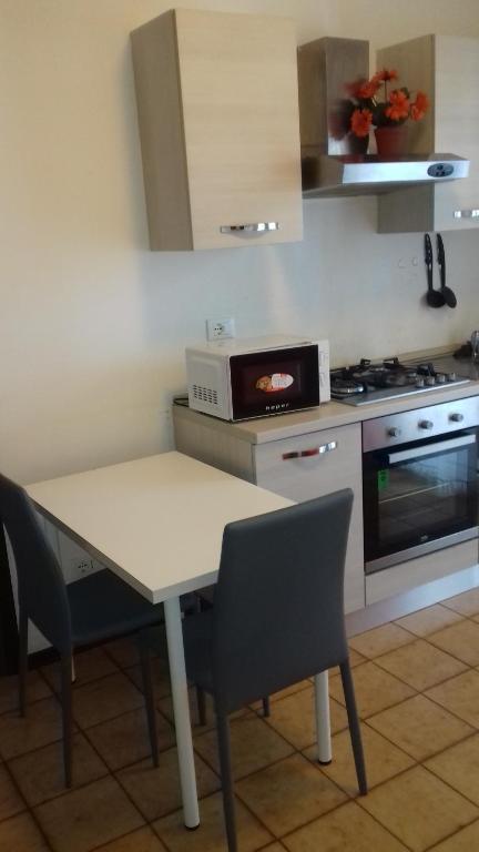 a kitchen with a table with chairs and a microwave at Monolocale Monticano in Motta di Livenza