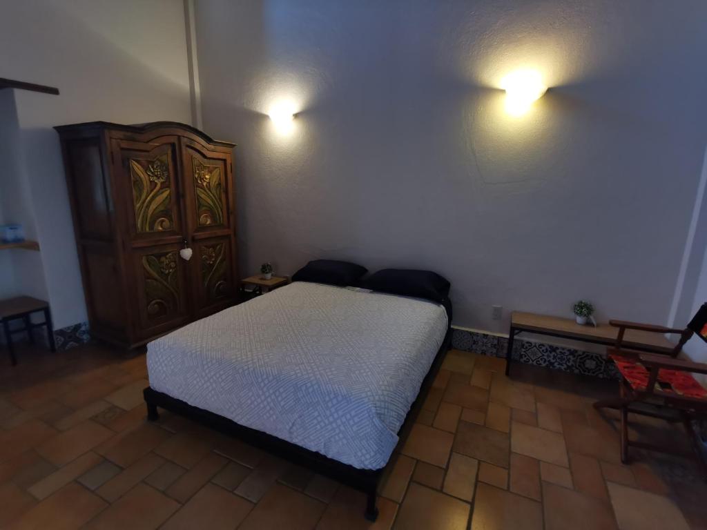 um quarto com uma cama, uma cómoda e luzes em Cozy, excellent location. em Oaxaca de Juárez
