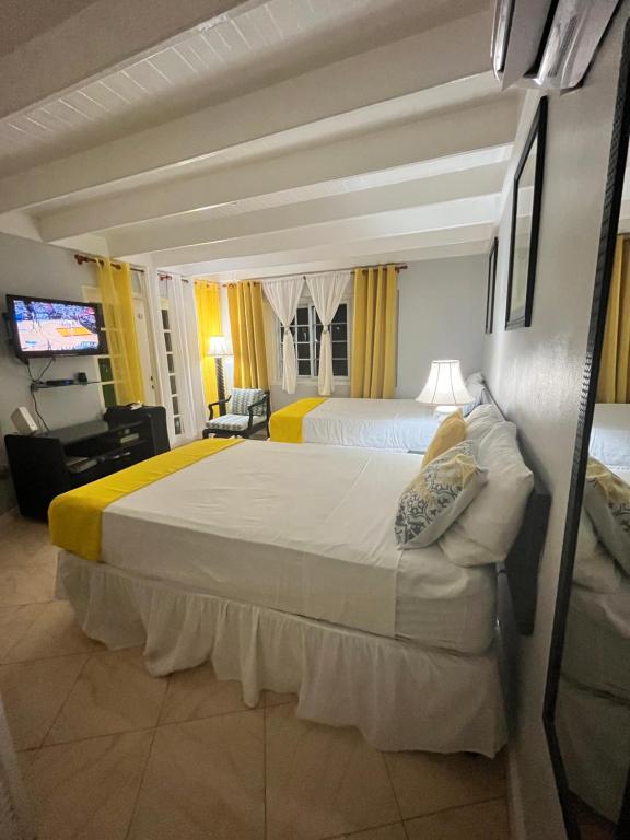 a hotel room with two beds and a television at Mystic Ridge Paradise in Ocho Rios