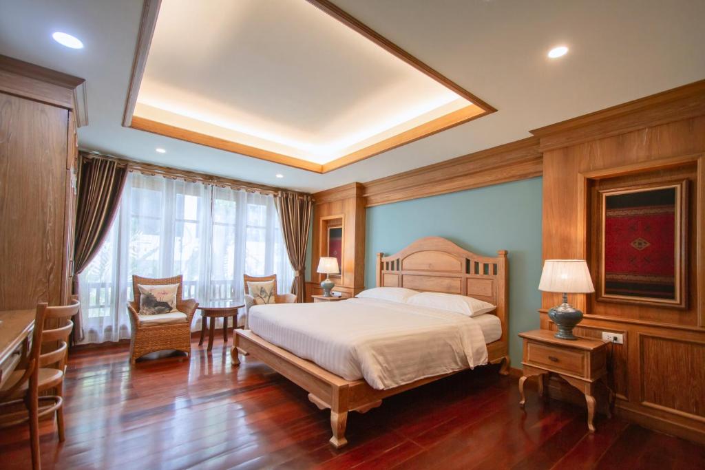 1 dormitorio con 1 cama, mesa y sillas en Rich Garden House Hotel, en Chiang Mai