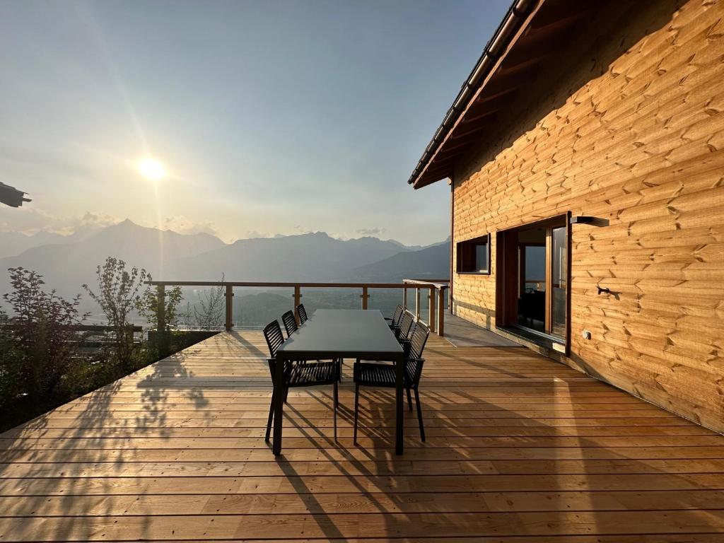 a table and chairs on a wooden deck with a view at Chalet Commaraf! - Swiss Alp 4 Vallees in Agettes