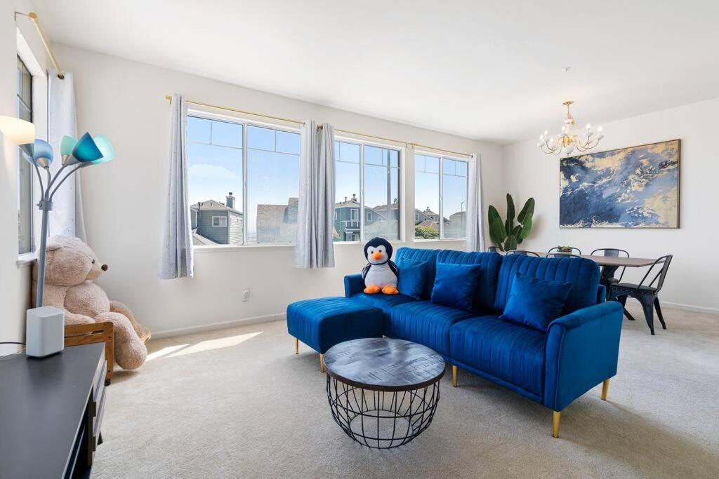 ein Wohnzimmer mit einem blauen Sofa und einem Tisch in der Unterkunft Nancy Homes - Private Rooms with private or shared bathroom and shared kitchen near Kaiser SFO in Daly City
