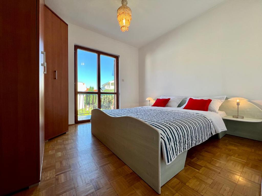 a bedroom with a bed and a tub and a window at Vodice Center Apartments in Vodice