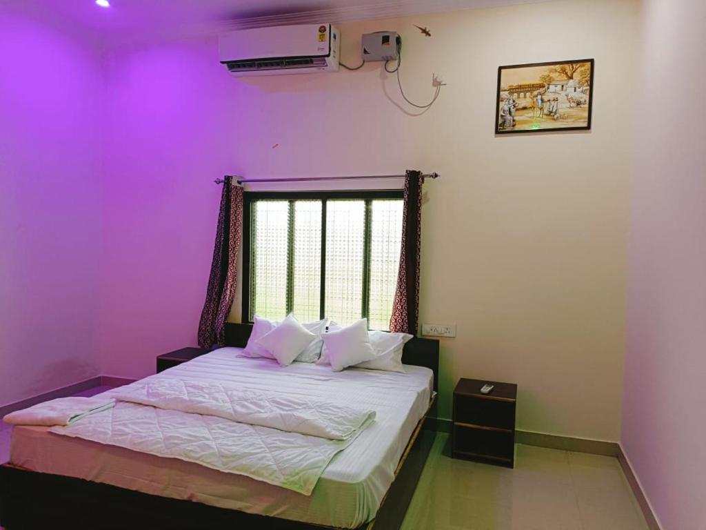 sypialnia z fioletowym pokojem z łóżkiem i oknem w obiekcie The Mountain View Home Stay w mieście Khajuraho