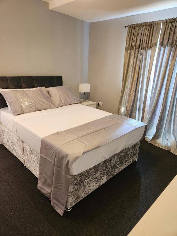 ein Schlafzimmer mit einem großen Bett und einem Fenster in der Unterkunft 4 Goodman Lodge & 7 goodman Lodge in Thornton Heath