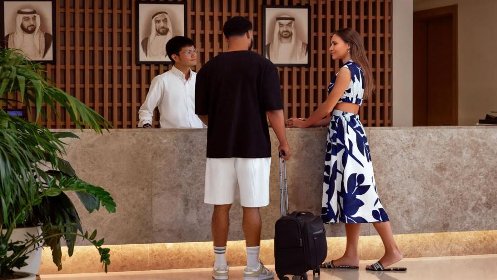 un hombre y una mujer de pie junto a una pared en Andalus Al Seef Resort & Spa, en Abu Dabi