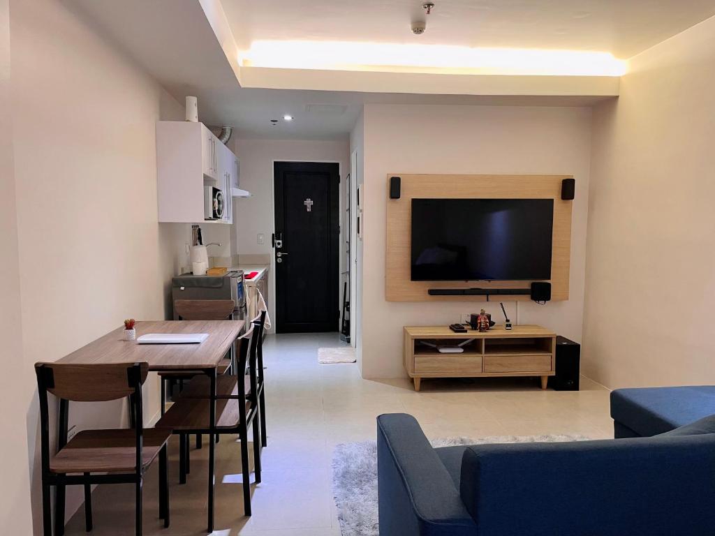 uma sala de estar com uma mesa de jantar e uma televisão em Studio Type - Matina Enclaves Residences em Dávao