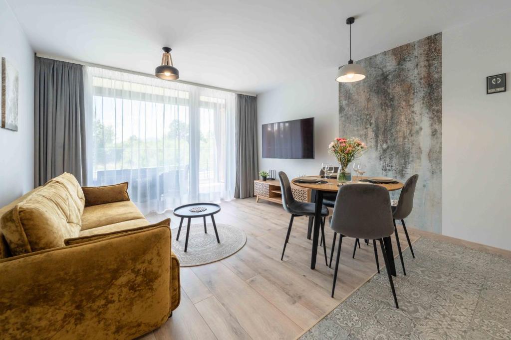 een woonkamer met een bank en een tafel bij Apartamenty Laguna Beskidów 80 i 81 Przy Jeziorze Żywieckim - Dream Apart in Zarzecze