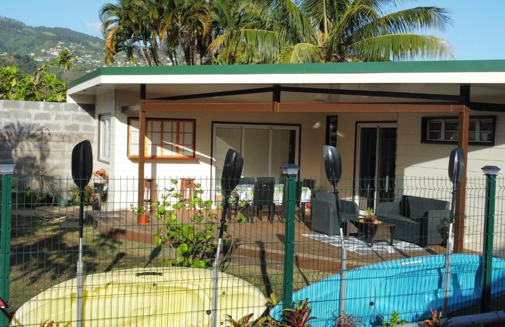 een huis met een hek rond een zwembad bij Kai Palmer Lodge in Punaauia