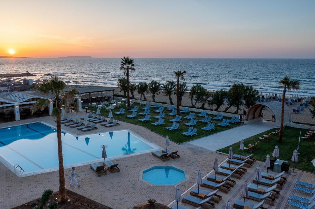 een luchtzicht op een resort met een zwembad en stoelen bij Malia Bay Beach Hotel & Bungalows in Malia