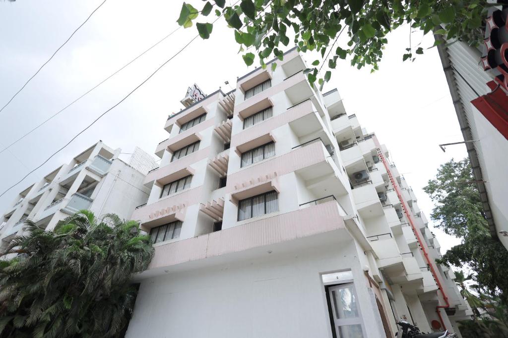 ein Apartmenthaus mit weißer Fassade in der Unterkunft Hotel Hospice in Surat