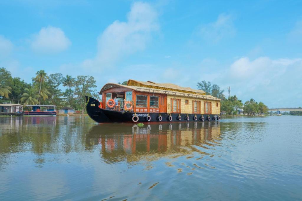 a boat with a house on the water at Angel Blue Houseboat Alapuzha in Alleppey