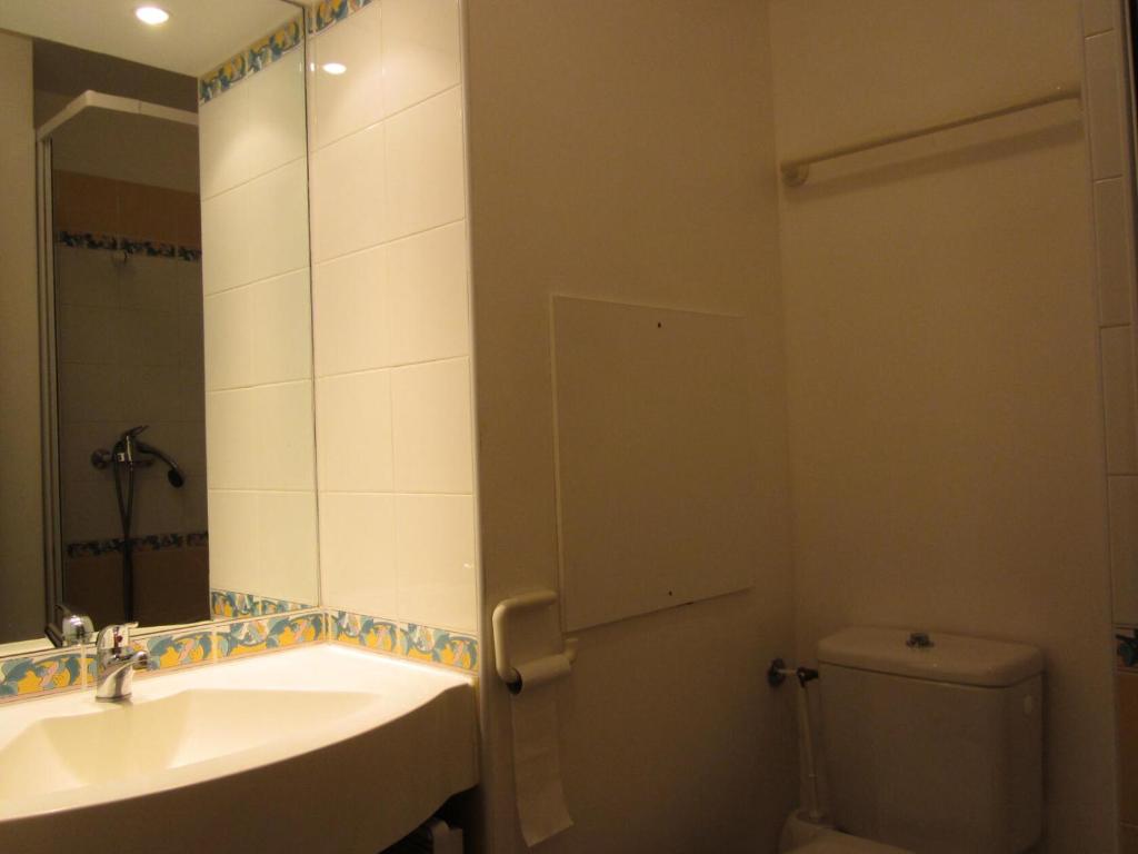 La salle de bains est pourvue d'un lavabo, de toilettes et d'un miroir. dans l'établissement LE MONT SOLEIL A - Appartement MONT SOLEIL A202 pour 6 Personnes 77, à Plagne Villages