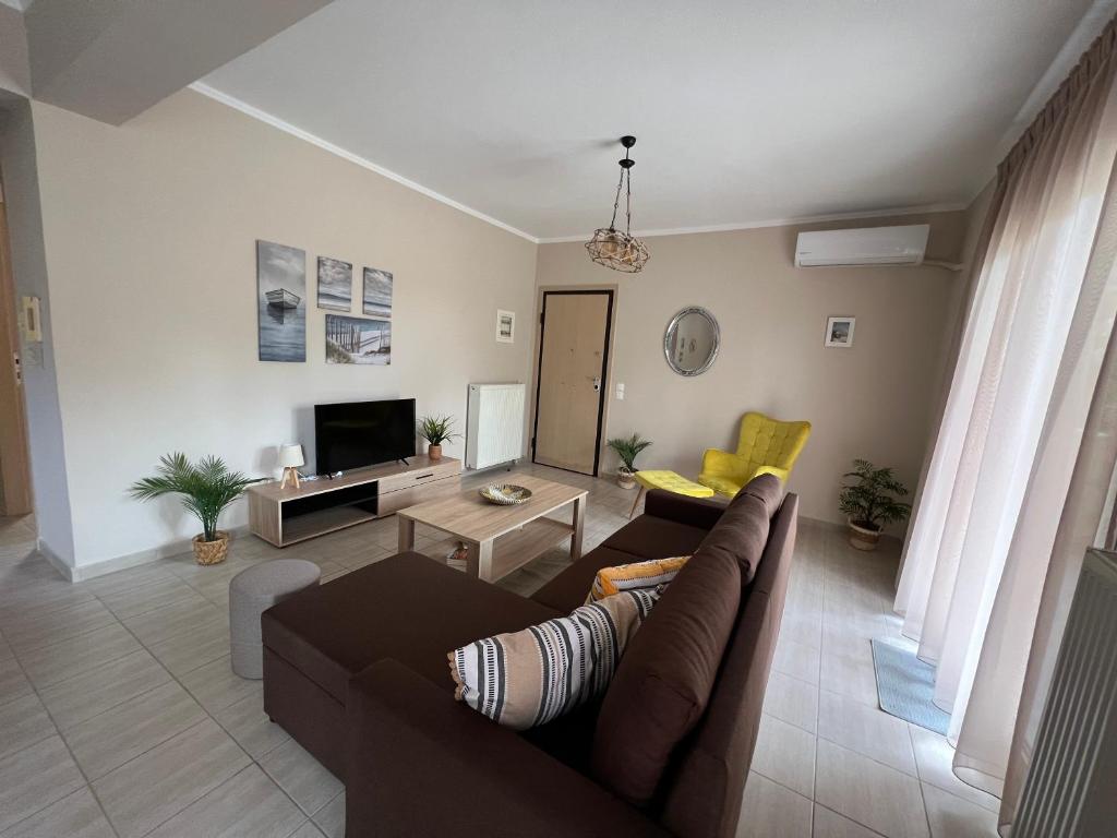 a living room with a couch and a tv at Navagio Luxury Apartment in Epanomi