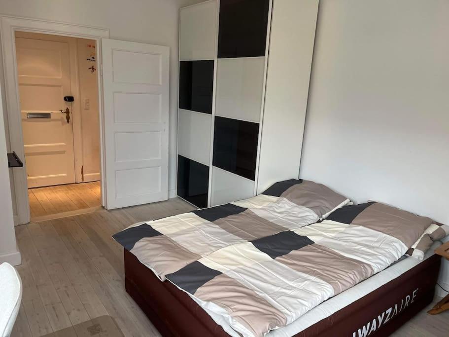 een slaapkamer met een bed met een dambordwand bij Familievenlig lejlighed tæt på Amager Strand in Kopenhagen