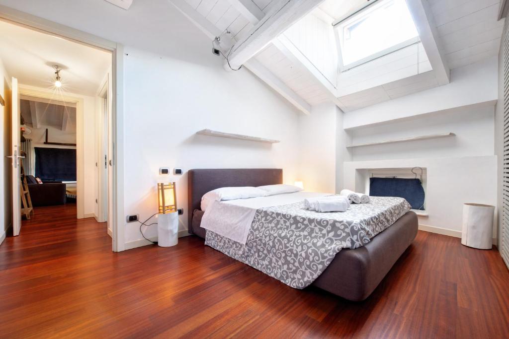 a bedroom with a large bed and a skylight at Penthouse in Città Alta - Bergamo in Bergamo