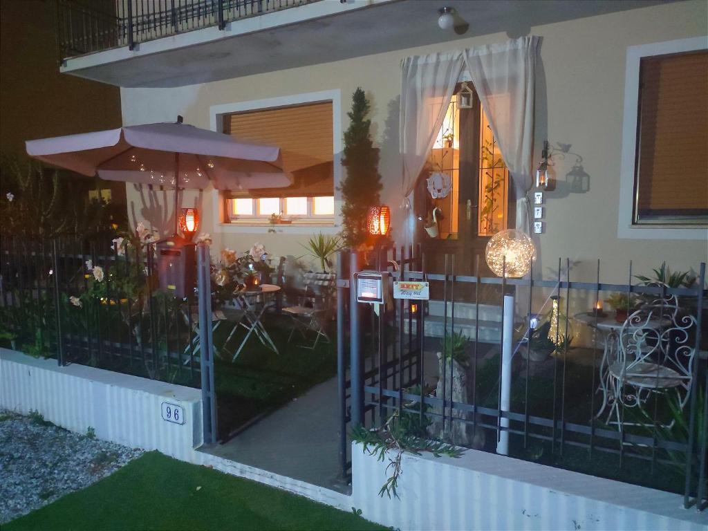 ein Haus mit einem Eisentor und einer Terrasse mit Tischen in der Unterkunft Luce in Lucca