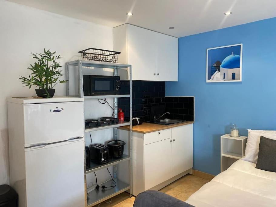 a kitchen with a white refrigerator and a microwave at Summer guest house with hottub and BBQ area in Winchmore Hill